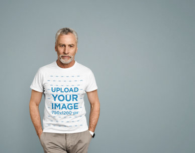 T-Shirt Mockup of a Senior Bearded Man Posing at a Studio 