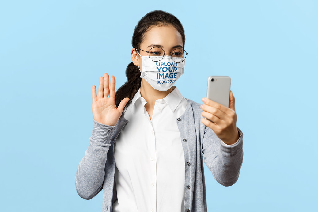 Studio Mockup of a Woman with a Face Mask Taking a Selfie