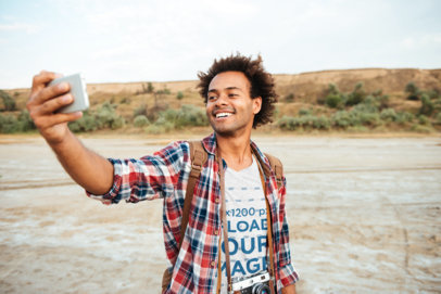 Heather Tee Mockup of a Happy Man Taking a Selfie 