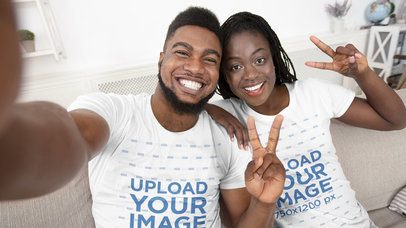 T-Shirt Mockup Featuring a Smiling Couple Taking a Selfie at Home
