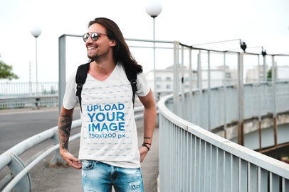 V-Neck T-Shirt Mockup of a Long-Haired Man Walking on an Urban Bridge