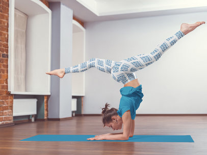 Mockup of a Woman Wearing Sublimated Leggings While Practicing Yoga 