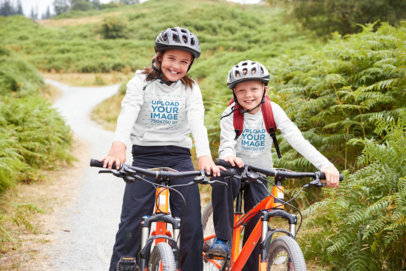 Hoodie Mockup of a Two Kids Biking in the Mountains