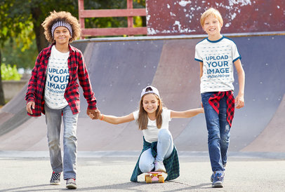 T-Shirt Mockup of Three Joyful Kids at a Skatepark 