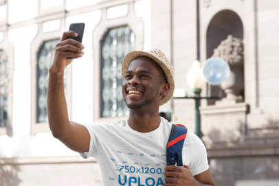 T-Shirt Mockup of a Man Taking a Selfie While Touring in the City