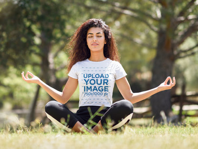T-Shirt Mockup of a Young Woman with Curly Hair Meditating in the Park