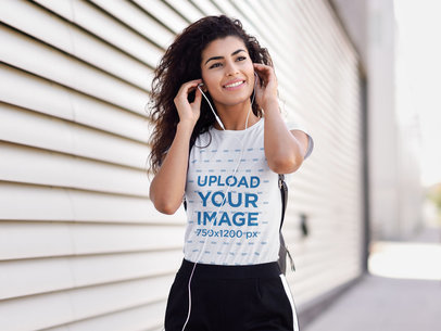 T-Shirt Mockup of a Young Woman with Curly Hair Putting on Headphones 