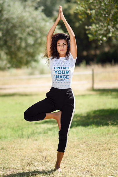 T-Shirt Mockup of a Woman Doing Yoga Outside on a Sunny Day