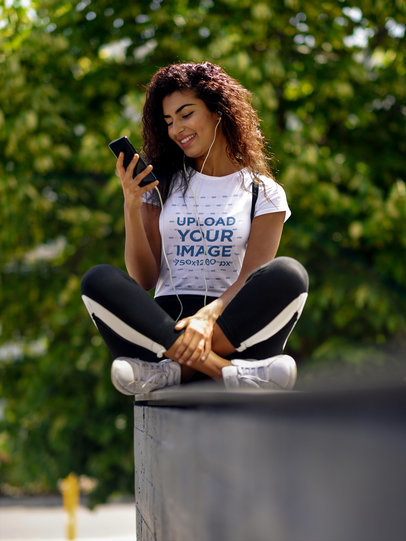 T-Shirt Mockup of a Young Woman Looking at Her Phone