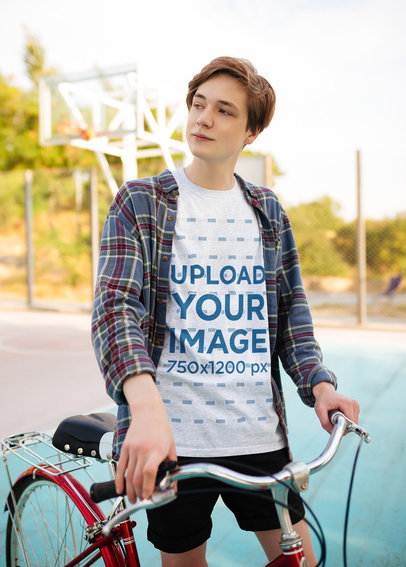 T-Shirt Mockup of a Man Posing with His Bike in a Suburban Setting