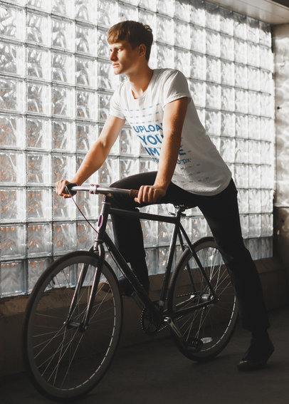 T-Shirt Mockup of a Young Man Riding a Bike Next to a Glass Wall 37798-r-el2