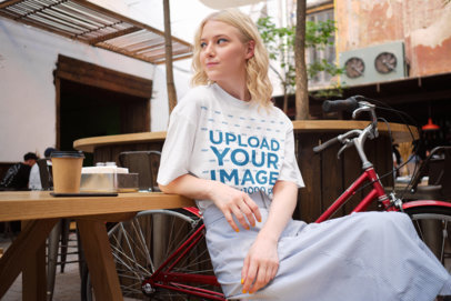 Unisex T-Shirt Mockup of a Woman at a Cafe