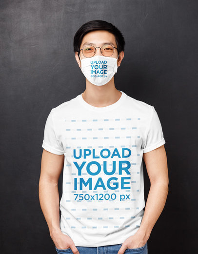 T-Shirt Mockup Featuring a Man With a Face Mask Standing Against a Dark Wall 