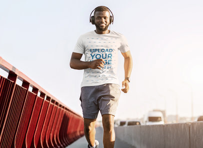 T-Shirt Mockup of a Man Wearing Headphones while Running on a Bridge