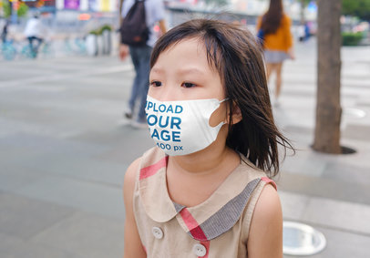 Face Mask Mockup Featuring a Little Girl Walking on the Street