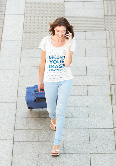 T-Shirt Mockup of a Woman Walking on the Street with a Suitcase