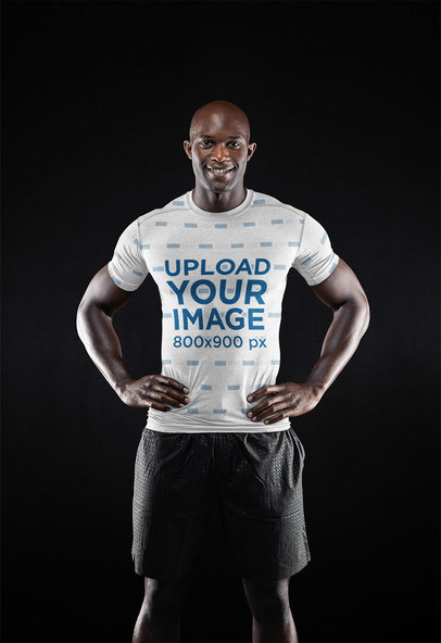 Mockup of a Muscular Man Wearing a Sublimated Tee in a Dark Setting