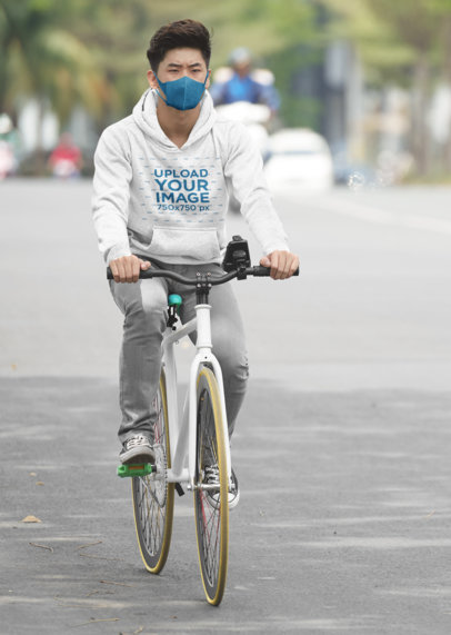 Pullover Hoodie Mockup Featuring a Man Riding a Bicycle