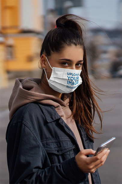 Face Mask Mockup of a Young Woman Checking Her Phone