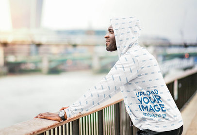 Mockup of a Man Wearing a Sublimated Hoodie while Looking at a River