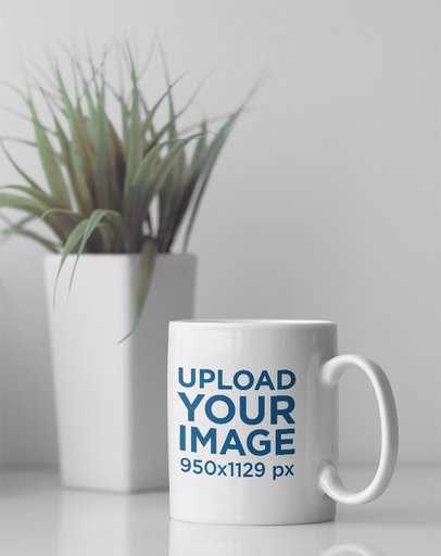 Mockup Featuring an 11 oz Coffee Mug Placed by a Small Plant Pot 