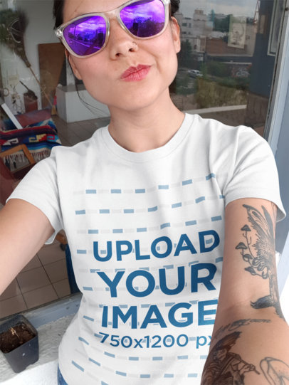 T-Shirt Mockup of a Tattooed Woman with Sunglasses Taking a Selfie