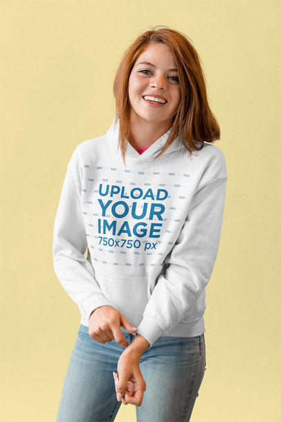 Mockup of a Smiling Woman Wearing a Hoodie and Adjusting Her Sleeve