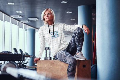 Mockup of a Woman Wearing a Heathered Hoodie at the Gym