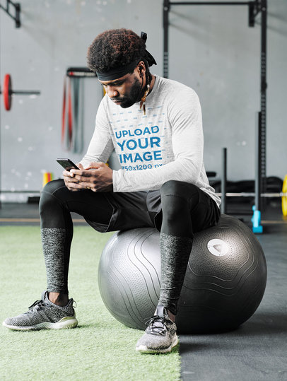 Mockup of a Man with a Heathered Long-Sleeve Tee Checking His Phone 