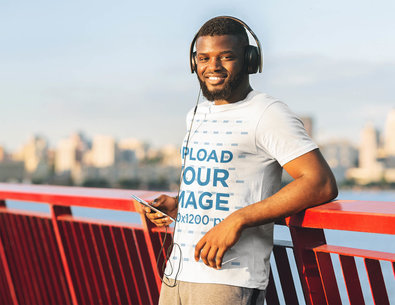 Mockup Featuring a Bearded Man with an Activewear T-Shirt Posing on a Bridge 