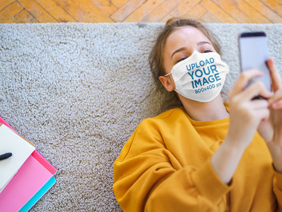 Face Mask Mockup of a Young Woman Looking at Her Phone