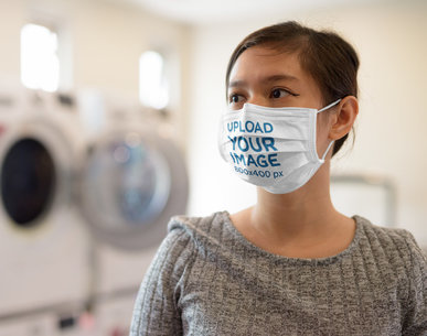 Mockup of a Woman Wearing a Face Mask at a Laundry Station