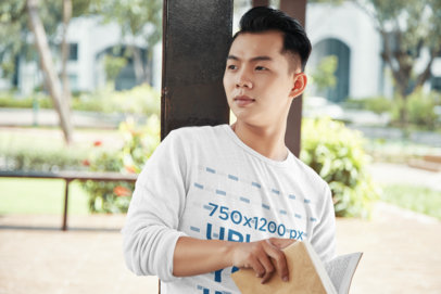 Sweatshirt Mockup Featuring a Young Man Reading Outside