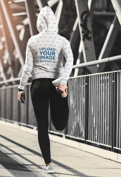 Back View Mockup of a Woman with a Sublimated Hoodie Stretching on the Street