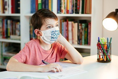 Face Mask Mockup Featuring a Serious Kid Studying 