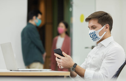 Face Mask Mockup of a Man Checking His Phone at the Office