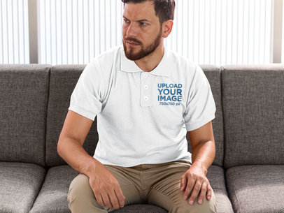 Polo Shirt Mockup of a Bearded Man Sitting on a Couch