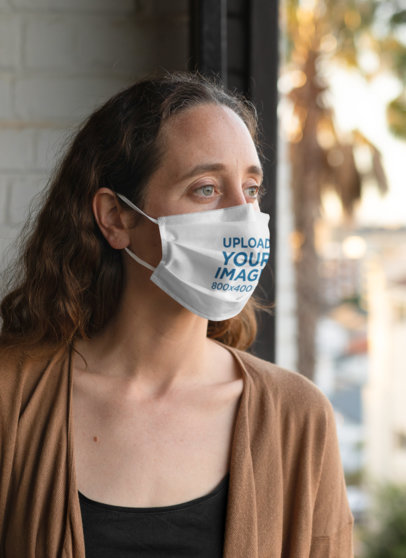 Face Mask Mockup of a Woman Standing By a Window 
