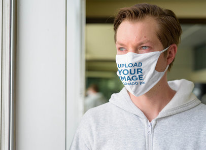 Face Mask Mockup of a Blue-Eyed Man Looking Out a Window
