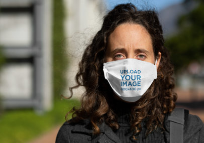 Face Mask Mockup Featuring a Serious Woman With Curly Hair 