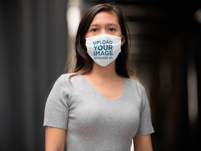 Mockup of a Woman with Long Hair Wearing a Sublimated Face Mask