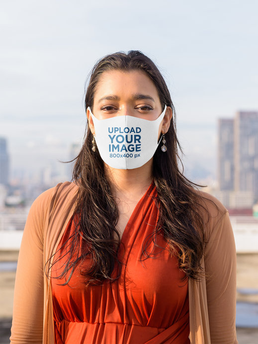Face Mask Mockup of a Woman Posing in Front of the City Skyline