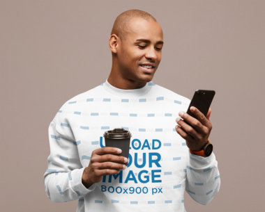Sublimated Sweatshirt Mockup Featuring a Man Checking His Phone at a Studio