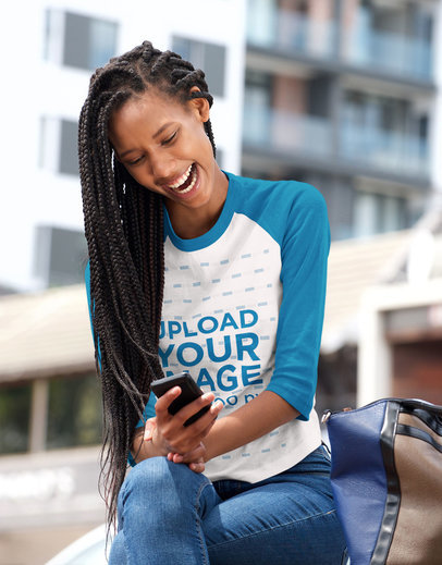 Raglan T-Shirt Mockup of a Woman Laughing While Looking at Her Phone