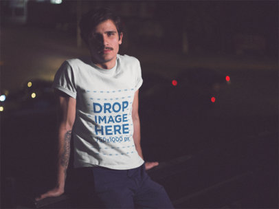 Young Man Looking At The Camera While Wearing A Short Sleeved TShirt In The City At Night a13619