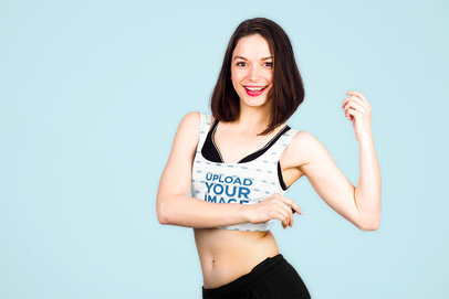 Mockup of a Happy Woman Wearing a Customizable Sports Bra Against a Plain Backdrop 35990-r-el2