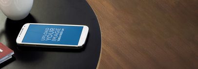 Wide Mockup of a Samsung Galaxy Placed on a Round Table