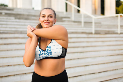 Plus-Size Sports Bra Mockup of a Woman Stretching on the Steps of a Building