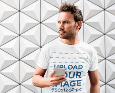 T-Shirt Mockup of a Bearded Man Holding a Phone 