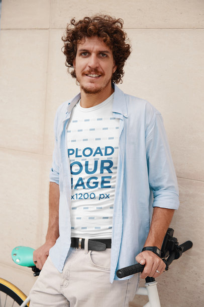T-Shirt Mockup of a Stylish Man Posing with His Bike
